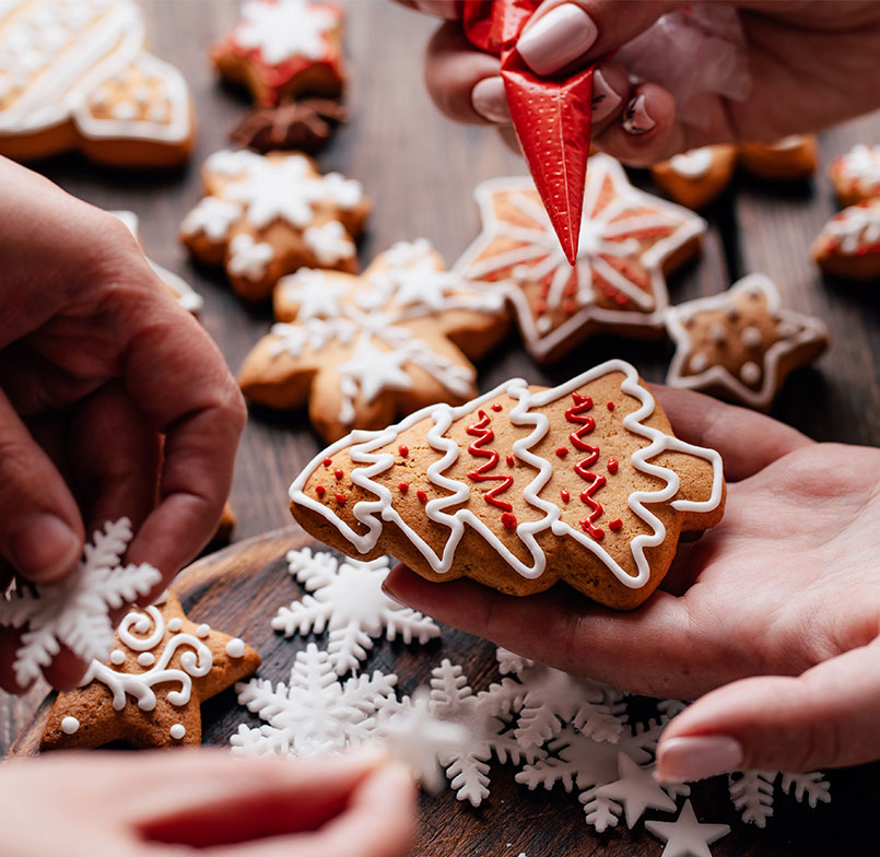 Beautifully decorated gingerbread Christmas tree cookie on the palm of a hand